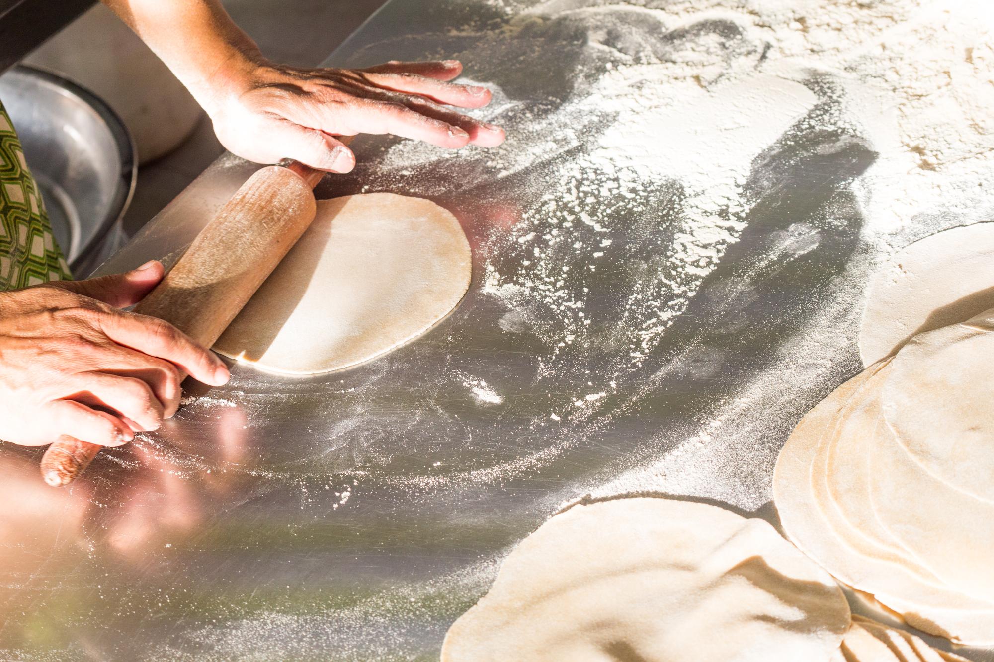 hands kneading dough in warm light