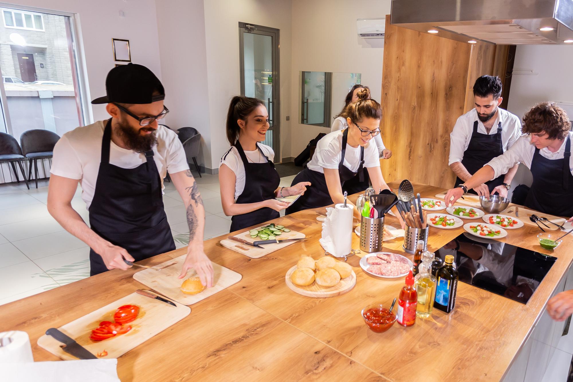 small class around a counter listening to chef